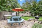 Amazing backyard patio space with hot tub, outdoor shower, picnic table, and BBQ grill